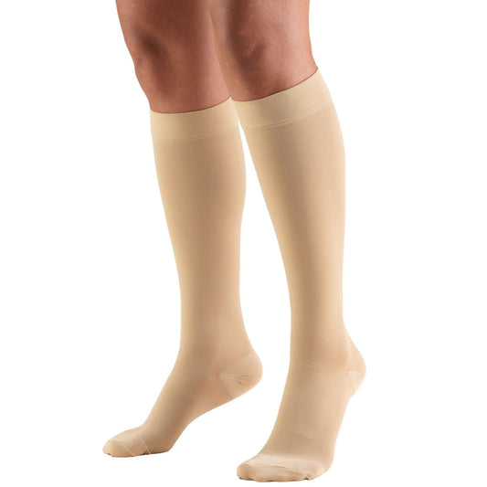 Model wearing knee high compression stockings. Beige color. Closed toe.