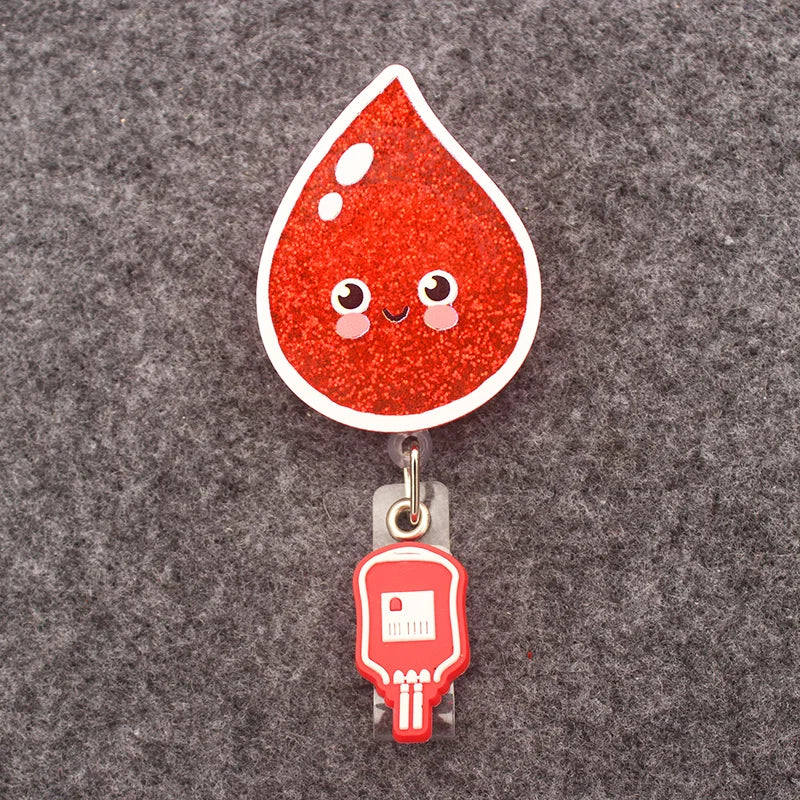 badge reel blood drop with smiley emoji. Under ID holder clasp, a blood bag.