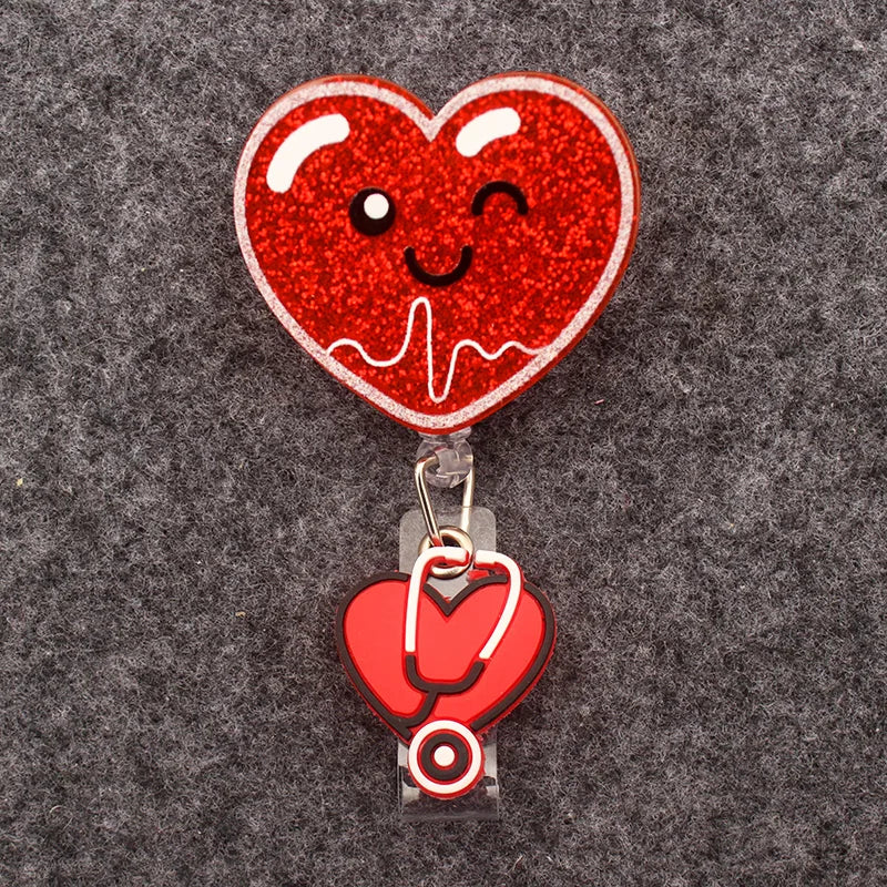 badge reel - winky heart face with EKG. Under ID holder clasp, a heart with stethoscope.