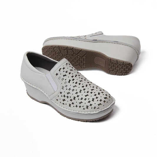 white clog shoes with hollow openings on top. slip on. 